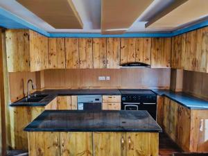 a kitchen with wooden cabinets and black appliances at Entire Home in Kathmandu, Grace - Residential in Kathmandu