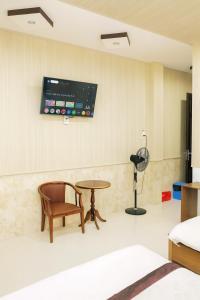 a room with a table and a tv on the wall at Yến Ánh Xuân Hotel in Phan Rang–Tháp Chàm