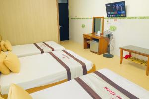 a hotel room with three beds and a television at Yến Ánh Xuân Hotel in Phan Rang–Tháp Chàm +25 photos