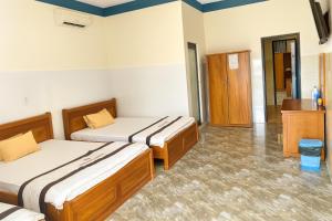 a hotel room with two beds and a bathroom at Yến Ánh Xuân Hotel in Phan Rang–Tháp Chàm