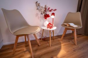 two chairs and a table with a vase and a candle at Sweet Embrace in Brno