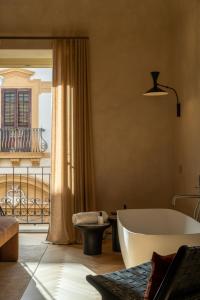 a large bathroom with a tub and a balcony at Palazzo Balsamo Boutique Hotel in Palermo