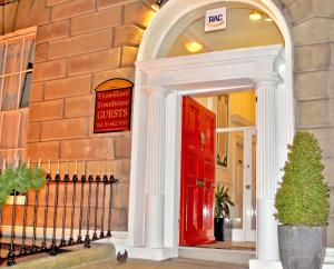 una puerta roja en el lateral de un edificio en Fitzwilliam Townhouse, en Dublín