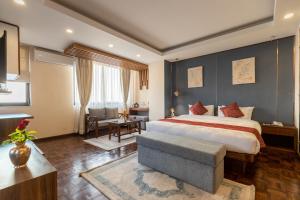 a bedroom with a king sized bed and a living room at Apex Business Hotel - Tribhuvan International Airport, Kathmandu in Kathmandu