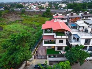 Nakshatra Villa by Palette Homes | 4BHK | Gazebo | BBQ | Pool | Rain Dance | Lonavala في لونافالا: اطلالة علوية على منزل بسقف احمر