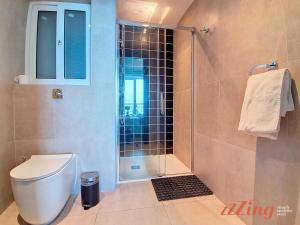 a bathroom with a shower with a toilet and a sink at South 32 Hotel by Zzzing in Birżebbuġa +29 photos