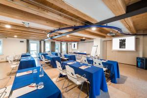 a conference room with blue tables and white chairs at Hotel Veronesi La Torre in Dossobuono +126 photos