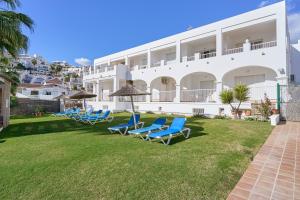 a row of blue chairs in front of a building at Apto 5 Almoraide Suites in Nerja