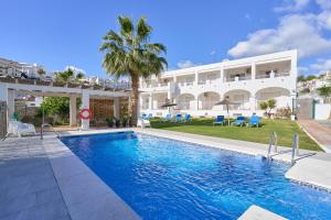 a swimming pool in front of a building at Apto 5 Almoraide Suites in Nerja