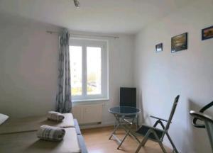 a living room with a couch and a table and a window at Comfortable room in a quiet apartment, exclusively for women in Dresden