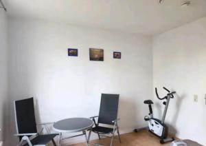 a room with a table and chairs and a table and a treadmill at Comfortable room in a quiet apartment, exclusively for women in Dresden
