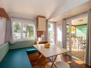 a small room with a table and a balcony at Camping Clos Cottet in Angles