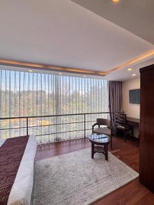 a hotel room with a bed and a desk and a balcony at Apex Business Hotel - Tribhuvan International Airport, Kathmandu in Kathmandu