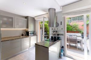 a kitchen with stainless steel appliances and a large window at Les Villas De Mandelieu in Mandelieu-La Napoule +21 photos