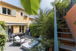 a patio with a table and chairs and a ladder at Les Villas De Mandelieu in Mandelieu-La Napoule