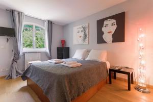 a bedroom with a bed with two pictures on the wall at Les Villas De Mandelieu in Mandelieu-La Napoule