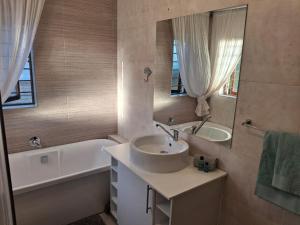 a bathroom with a sink and a tub and a mirror at 5Viooltjie in Riversdale +11 photos