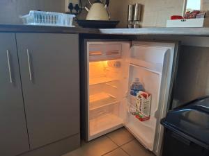 een lege koelkast met de deur open in een keuken bij 5Viooltjiestraat in Riversdale