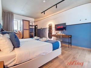 a bedroom with a large bed and a desk at South 32 Hotel by Zzzing in Birżebbuġa