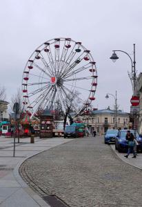Gold Glass z Jacuzzi &Sauną Rynek Centrum-Parking fv في كيلسي: عجلة فيريس كبيرة في مدينة بها سيارات متوقفة