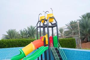 a water slide in a swimming pool at مزرعة أبو رامي ملعب كرة قدم ومسبح وألعاب مائية ومجالس واسعة in Al Kharj
