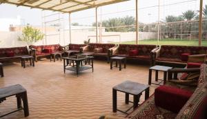 a large room with couches and tables and windows at مزرعة أبو رامي ملعب كرة قدم ومسبح وألعاب مائية ومجالس واسعة in Al Kharj +27 photos