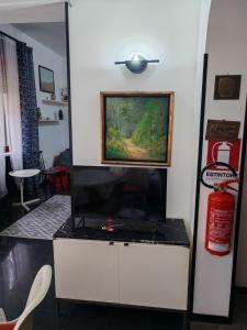 een woonkamer met een tv en een brandblusser bij Casa Guen Parma in Parma