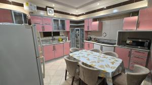 a kitchen with pink cabinets and a table and chairs at مسكن الهجرة in Medina