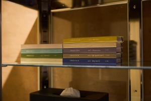a stack of books sitting on a glass shelf at 1日1組限定の宿 旅館 土と糸 Ryokan Tsuchi to Ito in Omi