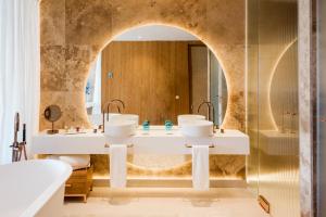 a bathroom with two sinks and a mirror at Aguas de Ibiza Grand Luxe Hotel - Small Luxury Hotel of the World in Santa Eularia des Riu