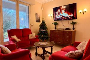 a living room with a christmas tree and red chairs at Clos de la Gare in Tournan-en-Brie