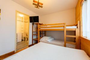 une chambre avec lits superposés et une télévision dans l'établissement Warm 29m with balcony and lake view, à Gérardmer