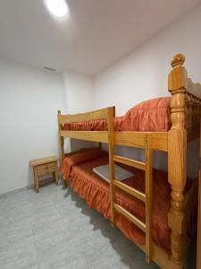 a bedroom with a wooden bunk bed with orange sheets at APCOSTAS - Complejo Al Andalus in Alcossebre +144 photos