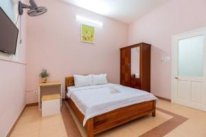 Un dormitorio con una cama y un televisor. en Savara Homes Garden City, en Vung Tau