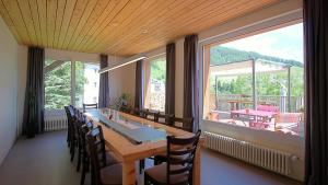 a dining room with a table and chairs and a large window at Hotel Bellavista Ftan in Ftan