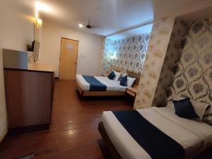 a hotel room with two beds and a television at THE CITY PARK HOTEl in Hyderabad