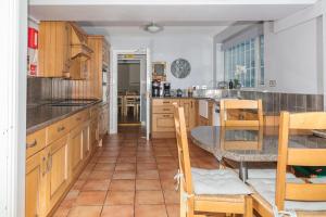 a kitchen with wooden cabinets and a table and chairs at Whitton Lodge Corporate in Chesterfield