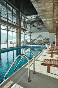 a large swimming pool with benches in a building at New Gudauri GN Apartments in Atrium in Gudauri