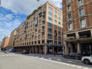 un edificio alto en una calle de la ciudad con coches aparcados en GetTheKey Marconi Apartments, en Bolonia