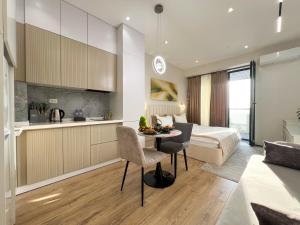 a bedroom with a bed and a table and a kitchen at NRG U- Tower in Tashkent