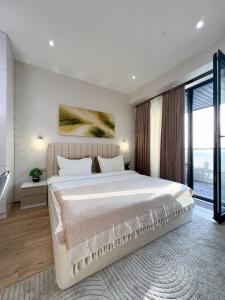 a bedroom with a large bed and a large window at NRG U- Tower in Tashkent