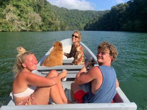 three people and a dog in a boat on a lake at La Isla Dulce in Lívingston