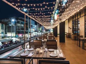 un restaurant avec des tables, des chaises et des lumières dans l'établissement Movenpick Suriwongse Hotel Chiang Mai, à Chiang Mai
