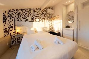 a bedroom with a large white bed with two pillows at VILLA MARINA CANNES in Cannes