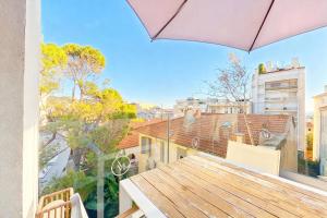 a balcony with a table and an umbrella at VILLA MARINA CANNES in Cannes