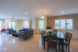 a living room with a dining table and a kitchen at Marina Island Lumut 3 Bedroom Holiday Apartment in Lumut