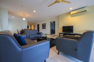 a living room with couches and a flat screen tv at Marina Island Lumut 3 Bedroom Holiday Apartment in Lumut