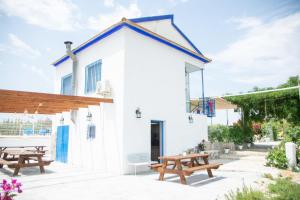 Un edificio blanco con mesas de picnic y bancos. en Mi Recreo - Casa Rural en Murcia, en Ojós