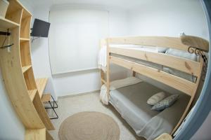 Habitación pequeña con literas y alfombra. en Mi Recreo - Casa Rural en Murcia, en Ojós