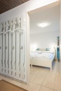 a white room with two beds and a doorway at Zuhause in den Alpen Ihre Ferienwohnung mit Hallenbad und Sauna in Lenzerheide